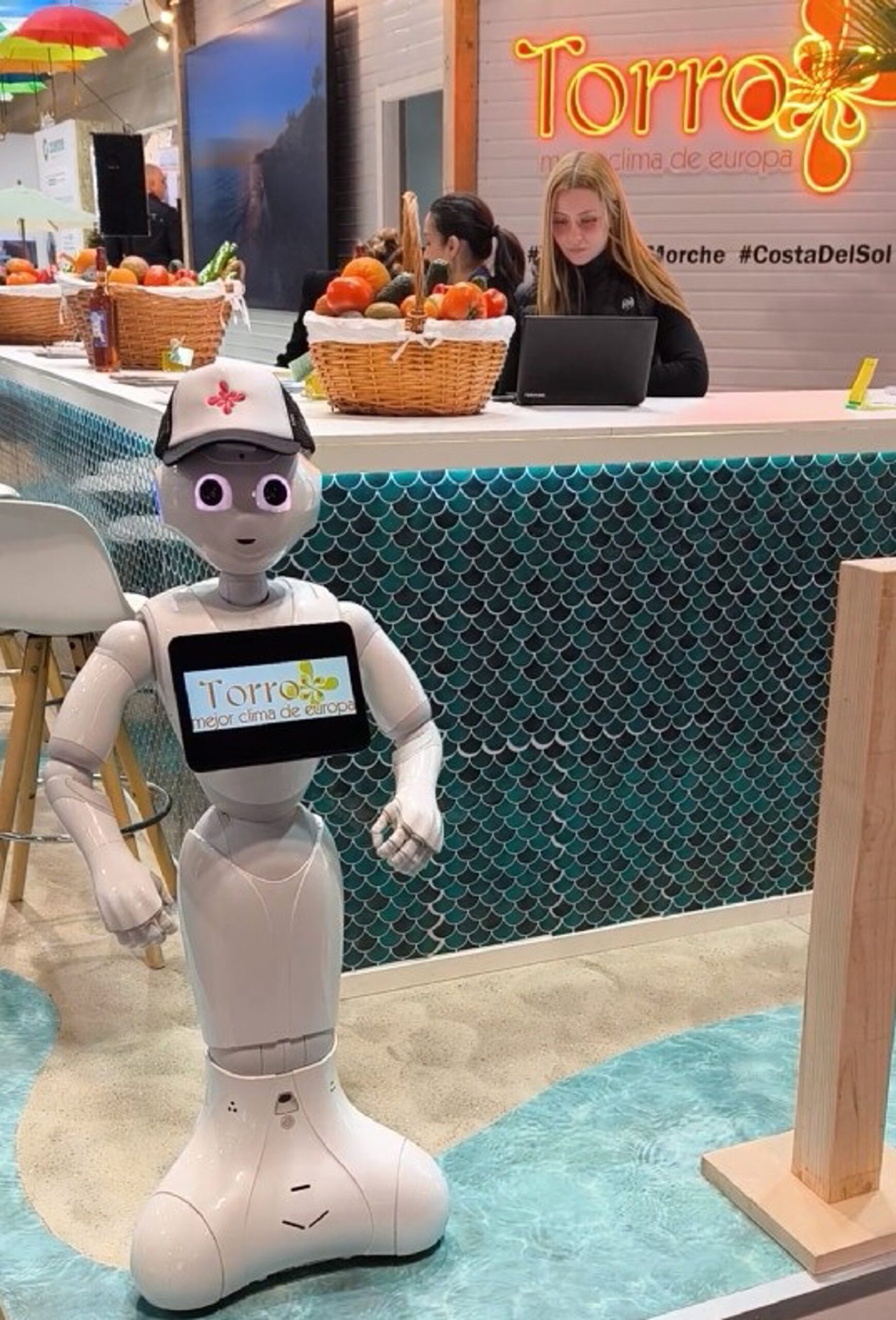 Unos robots humanoides reciben a los visitantes del estand de Torrox en Fitur